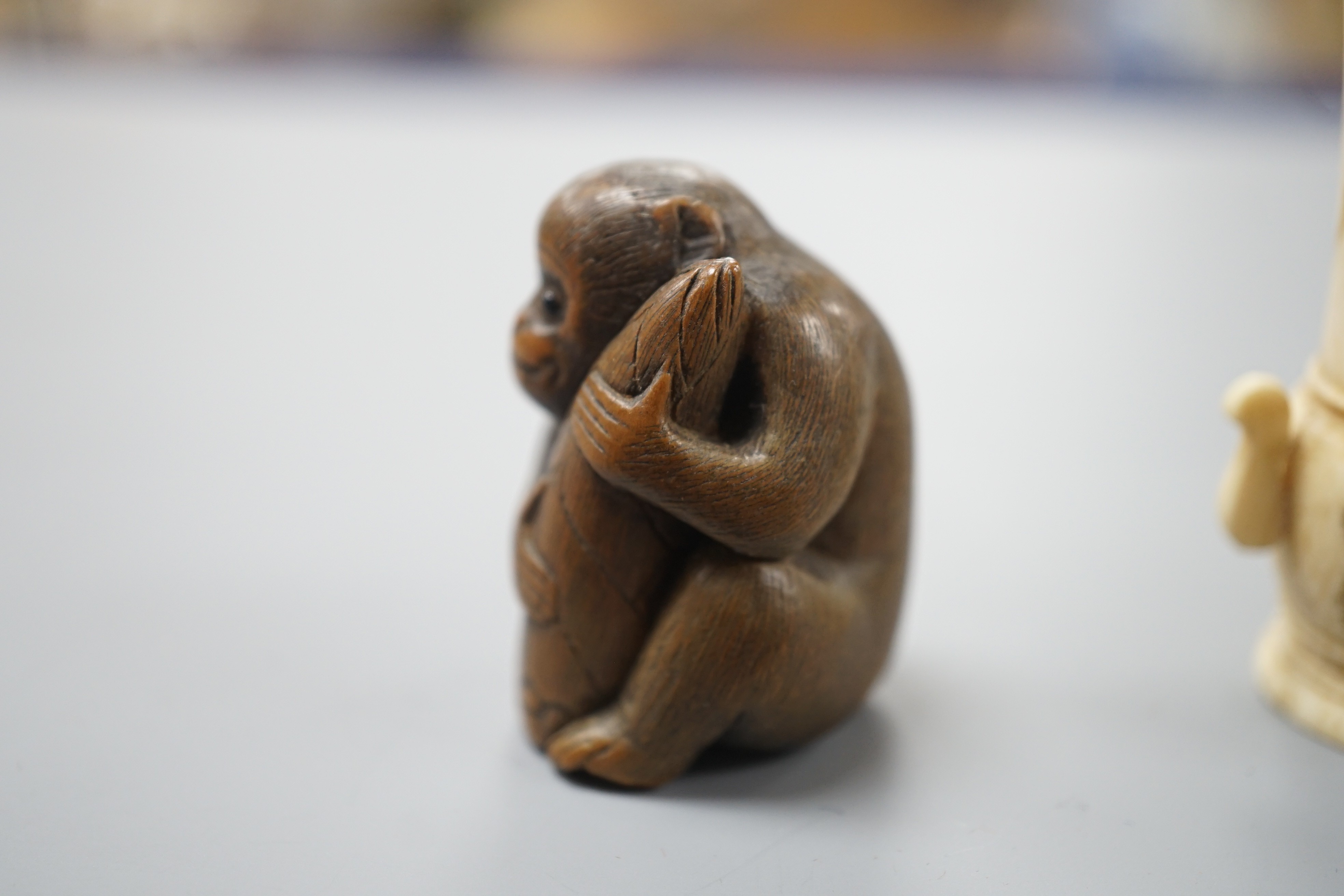A pair of early 20th century Japanese miniature ivory vases, 5.3 cm, engraved with a lady and a wood netsuke in the form of a monkey holding a bamboo shoot (3)